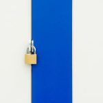 Padlock securing a blue and white striped door, symbolizing safety.