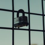 <h1>Securing the Grid: Risk-Sensitive Secure Multiparty Computation (SMPC) in Energy Systems</h1> Close-up of a steel padlock on a mesh fence, symbolizing protection and security.