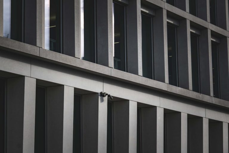 Contemporary office building exterior featuring multiple windows and security cameras.