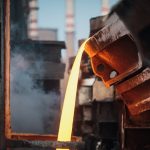 Close-up of molten metal pouring in a foundry, showcasing industrial processes.