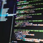 Close-up of colorful programming code displayed on a computer monitor with a dark background.
