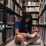 <h1>Self-Evolving Zero-Knowledge Proofs: The Future of Verifiable AI</h1> A young woman sitting on the floor of a library, reading a book intently.