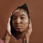 <h1>Self-Healing Connectomics: The Future of Neural Interfaces in Healthcare</h1> African American woman with Band-Aids looks into a shattered mirror, reflecting self-acceptance.