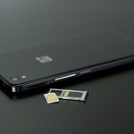Close-up of a smartphone with a SIM card and memory card, showcasing modern technology.