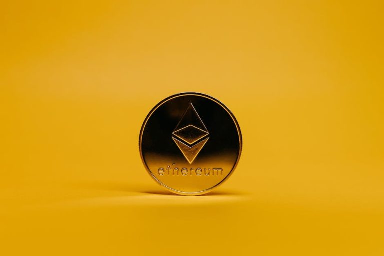 A shiny Ethereum coin displayed on a vibrant yellow background, symbolizing cryptocurrency.