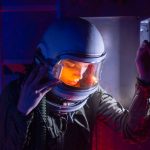 A woman astronaut in a helmet reflecting during an interstellar mission.
