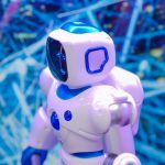 Standardizing Autonomous Agent Systems for Scale Close-up of a white and blue robot against a dynamic, futuristic tech backdrop.