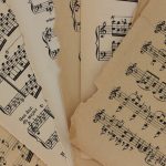 <h1>Symbol-Grounded Edge Orchestration: The New Standard for Distributed Ledgers</h1> Close-up of vintage sheet music with torn edges, highlighting musical notations and history.