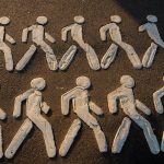 Creative chalk drawings of pedestrian figures on an urban pavement.