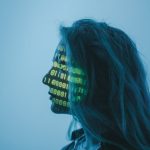 Silhouette of a woman with binary code projected on her face in a digital concept setting.