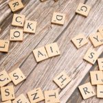 The Algorithmic Ego: How Automation Reshapes Modern Philosophy Wooden letter tiles scattered on a textured surface, spelling 'AI'.