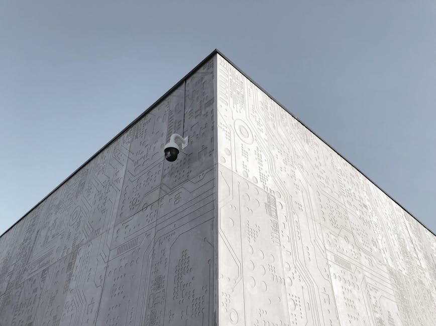 Elevated view of a futuristic building corner in Moscow, featuring circuit design patterns and a security camera.