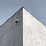 <h1>The Architecture of Autonomy: Self-Evolving Generative Simulation Interfaces</h1> Elevated view of a futuristic building corner in Moscow, featuring circuit design patterns and a security camera.