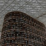 Discover the stunning design of a modern library with towering curved bookshelves.