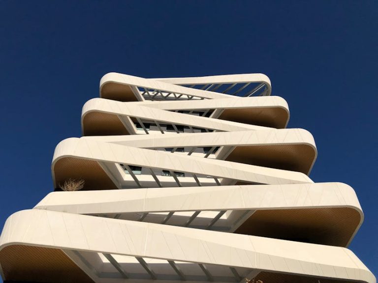 Striking low-angle view of a modern high-rise building in Madrid against a clear blue sky.