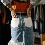 Close-up of denim skirt and hands in pockets, stylish scene indoors.
