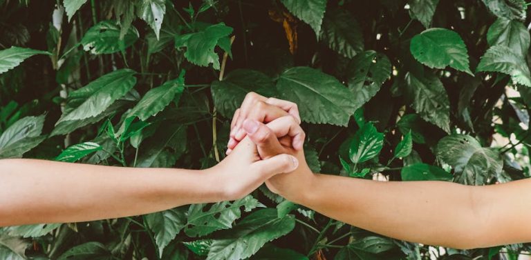 Two individuals clasp hands amidst lush foliage in Rio de Janeiro, symbolizing unity and friendship.
