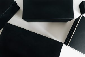 Top view of sleek black boxes arranged artfully on a white surface, showcasing minimalist design.