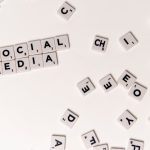 The Digital Paradox: How Social Media Distorts Spiritual Depth Scrabble tiles spelling 'Social Media' on a white background, symbolizing digital communication.
