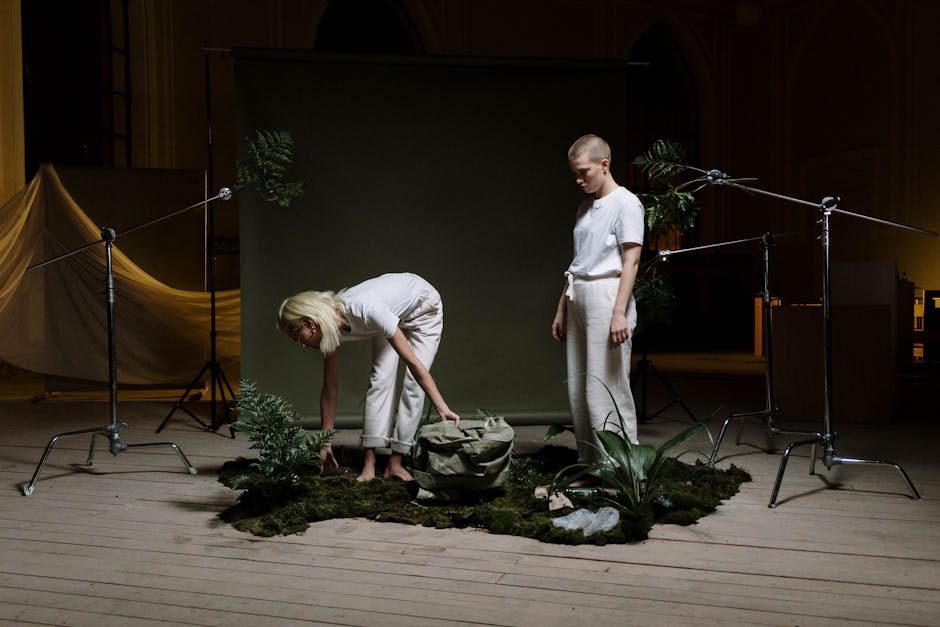Two individuals in a creative indoor setup with plants and eco-friendly theme.