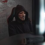 The End of Anonymity: How Privacy Shifts Power in History A mysterious person in a Guy Fawkes mask working at a computer, symbolizing cyber security themes.