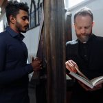 The Ethical Risks of Spiritual Integration in Modern Innovation A solemn moment of confession between a devoted man and a priest in a church setting.