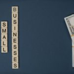 Conceptual image of supporting small businesses with financial resources using money and letter tiles.