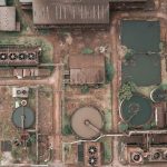 The Evolution of Environmental Aging: A Strategic Perspective Drone view of abandoned chemical plant with rusty and unused production buildings and round tanks with dirty water