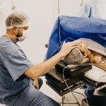 Surgeon offering comfort to a patient about to undergo surgery in a hospital operating room.