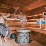 The Evolution of Wellness as a Strategic Leadership Competency Three people enjoying a steamy sauna session, embracing wellness and relaxation.