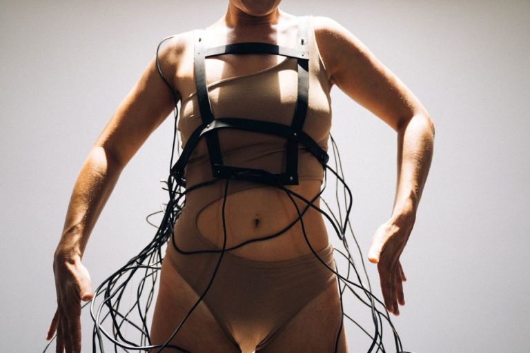 A woman models futuristic attire with wires, highlighting cyberpunk and modern aesthetics.