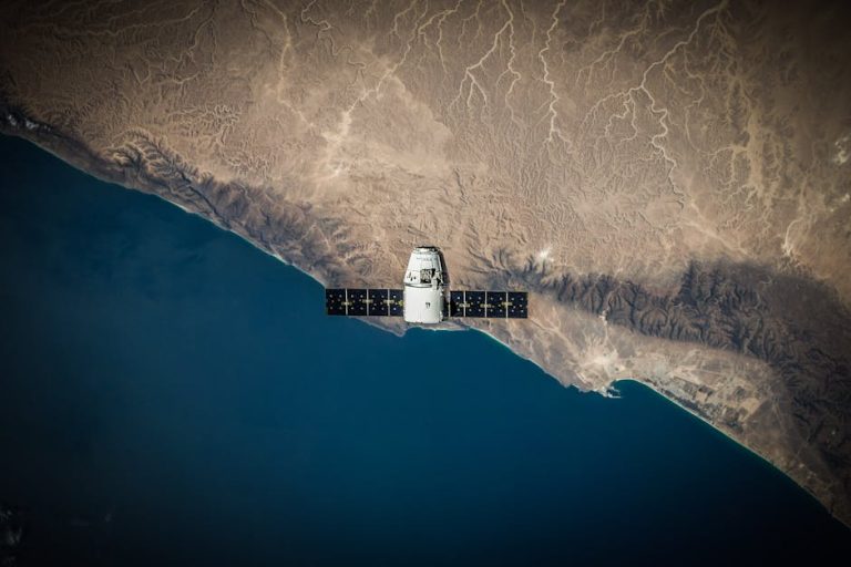 A satellite hovering above Earth's coastline, captured from space.