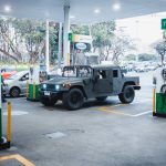 <h1>The Frontier of Bioelectronic Medicine: Integrating Physics-Informed Systems and Neuroethics</h1> A rugged Hummer H1 parked at a busy gas station in an urban setting.