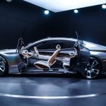 Sleek and modern concept car displayed indoors with open scissor doors, highlighting its futuristic design.