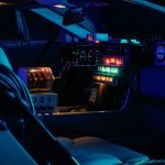 A dark futuristic car cockpit with glowing neon lights and digital displays.