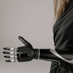 Close-up of a woman wearing a sleek, modern prosthetic arm. Studio shot emphasizes technology and innovation.