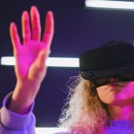 A woman engaged in virtual reality, wearing a headset and interacting with the virtual environment.
