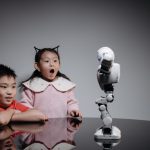 <h1>The Future of Learning: Implementing Cooperative Embodied Intelligence in EdTech</h1> Two children fascinated by a toy robot, showcasing excitement and curiosity indoors.