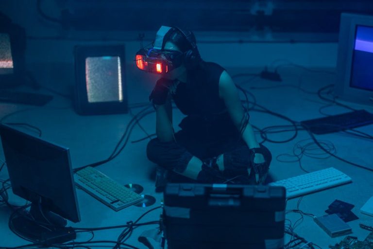 A woman in a dark room wearing a VR headset surrounded by retro technology.