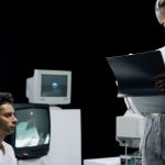 A futuristic lab with scientists reviewing a digital screen and data.