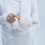 <h1>The Future of Touch: Implementing Decentralized Soft Robotics Protocols in HCI</h1> Person in white interacting with a clear glass interface, suggesting technological innovation.