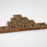<h1>The Future of Truth: Explainable On-Orbit Manufacturing for Synthetic Media</h1> Close-up of wooden Scrabble tiles on a white background spelling 'I Am The Truth'.