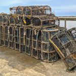 Lobster pots stacked by the water in Staithes, England, ready for fishing at the harbor.