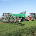 <h1>The Green Fertilizer Revolution: Building a Competitive Synthetic Fertilizer Simulator for Climate Tech</h1> Tractor and manure spreader on green farmland in Lütau, Schleswig-Holstein, Germany.