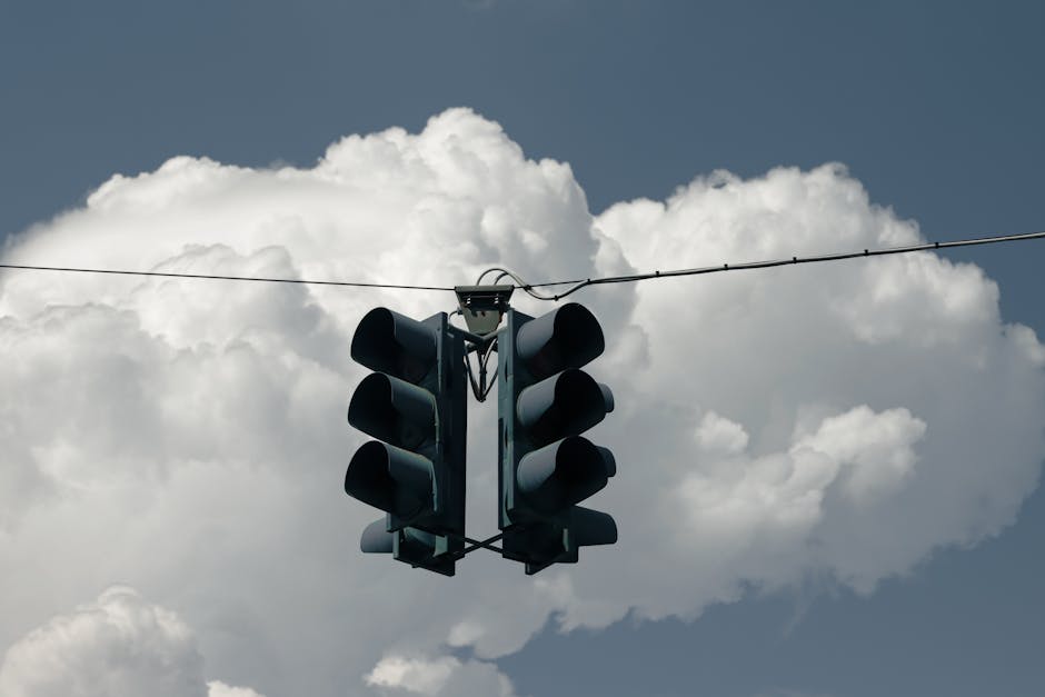A traffic light suspended against a backdrop of dramatic clouds in Palermo, Sicily.