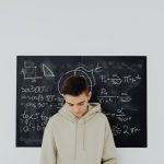 <h1>The Mathematics of Human-in-the-Loop Bioelectronic Medicine: Engineering the Neural Interface</h1> Teenager in a classroom solving mathematics equations on a blackboard, deep in thought.