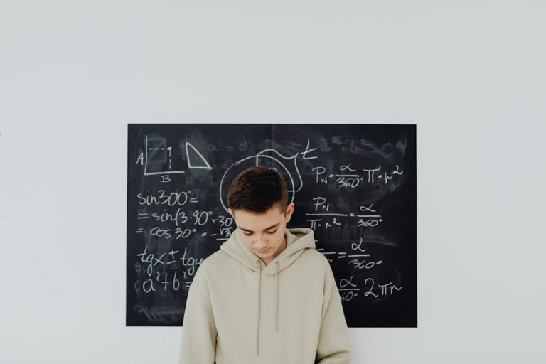 Teenager in a classroom solving mathematics equations on a blackboard, deep in thought.