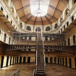 Interior view of historic Kilmainham Gaol in Dublin, showcasing Victorian architecture and prison cells.