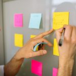 The Post-Feed Era: Strategic Shifts in Social Media Technology Focused businessman writing ideas on sticky notes for planning and organization.