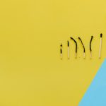 The Psychology of Failure: Turning Strategic Loss into Operational Gain Artistic representation of burnout using matches and blocks spelling 'STOP BURNOUT' on colorful background.